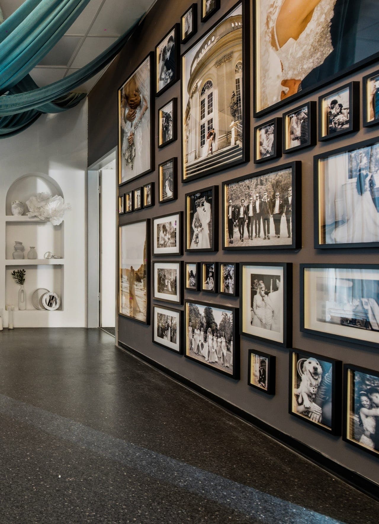 Galerie-Bilderwand des Studios mit Bogen-Nische und Samt-Drapierung